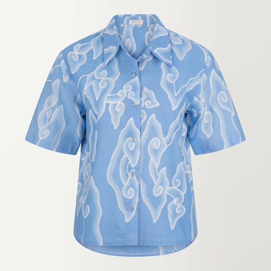 A blue cotton batik shirt with a collared neck, short sleeves, and a longer hem at the back.